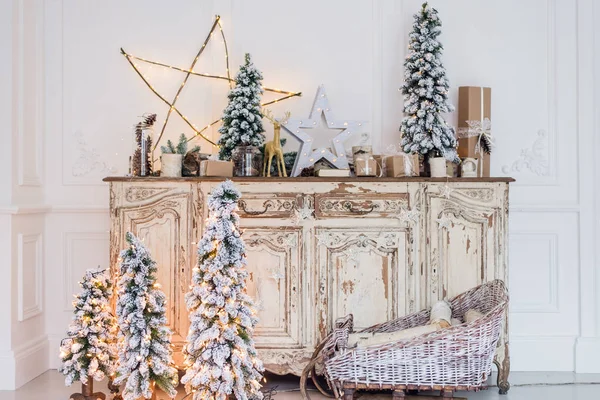 Decoración de Navidad en la antigua cómoda antigua vintage de cajones. Regalos artesanales hechos a mano, velas y un árbol al fondo. — Foto de Stock