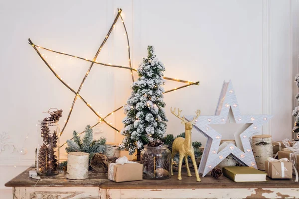 Dekoracja świąteczna na starej komodzie komody komody. Ręcznie robione prezenty, świece i drzewo w tle. — Zdjęcie stockowe