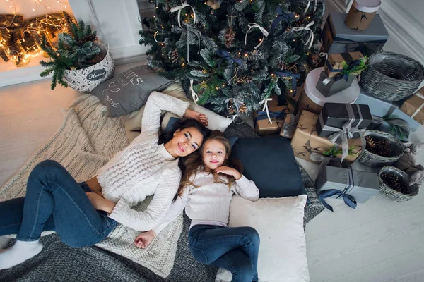 Красива щаслива родина мати і дочка з подарунками навколо ялинки знаходяться на підлозі разом вдома — стокове фото