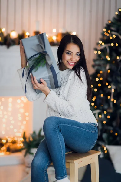 Femme heureuse excitée d'ouvrir cadeau de Noël assis à la maison devant un arbre de Noël et une cheminée — Photo
