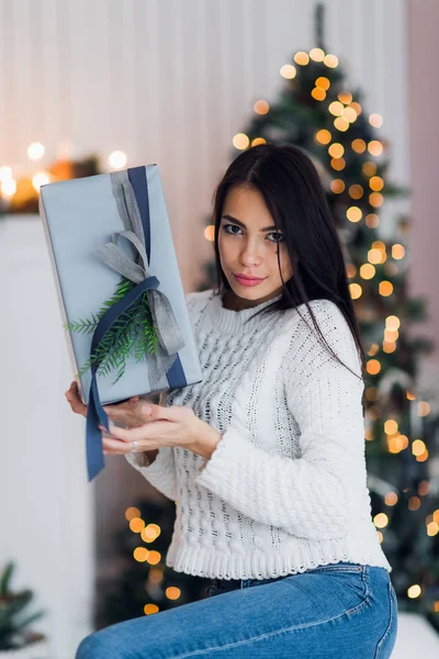 Щаслива жінка Радісна Різдвяний подарунок сидить вдома перед ялинкою і каміном — стокове фото