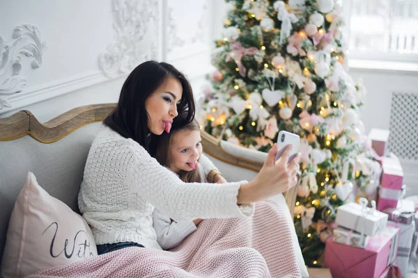 Main bien entretenue d'une femme tenant un téléphone prenant un selfie avec sa fille, petite fille — Photo