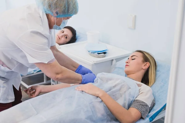 Enfermeira conectando um gotejamento intravenoso no quarto do hospital . — Fotografia de Stock