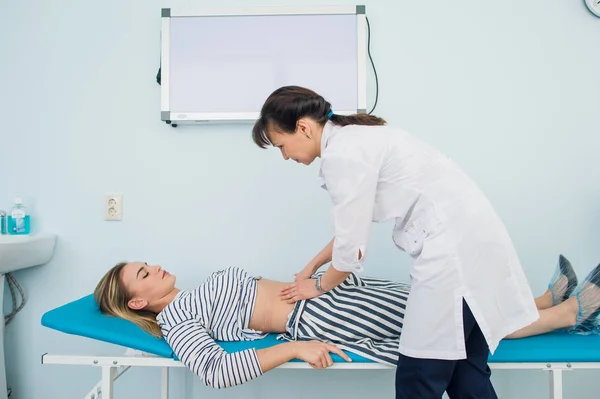 Ręce lekarze badając brzuch kobiety — Zdjęcie stockowe