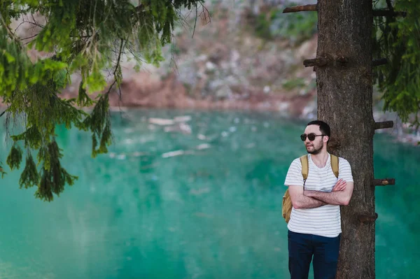 Skäggig man modell poserar tillsammans med en Green vatten sjö. — Stockfoto