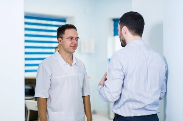 Γιατρό του μιλώντας σε έναν ασθενή σε ένα διάδρομο — Φωτογραφία Αρχείου