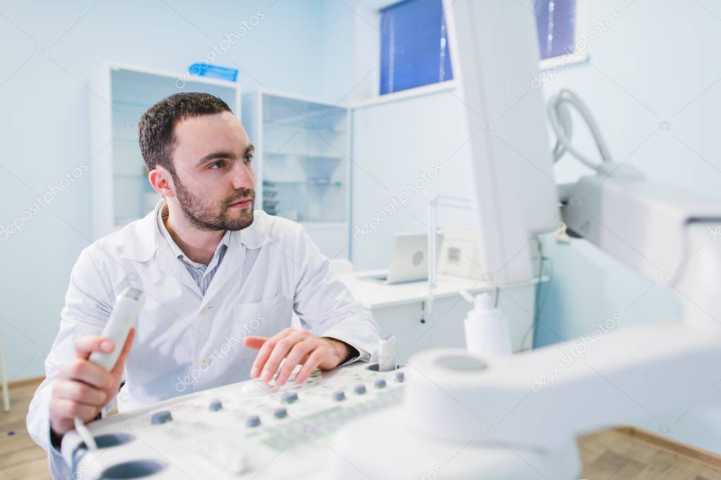 handsome doctor using an ultrasound machine