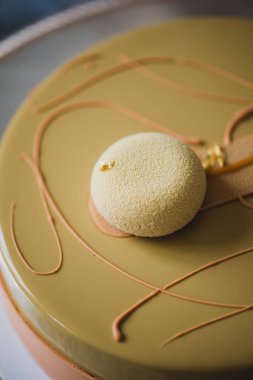 Badem dacquoise, ahududu confit, gevrek katmanla karamelize fındık ve ahududu tozu ile sarı puding kek fırından yeni çıkmış, ahşap masaya servis bağlı olarak bitter çikolata mousse