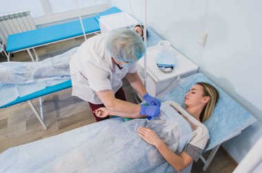 Profesyonel hemşire işletim masa anestezik tıbbi sağlık cerrahi konsept hazırlama hastanede yatan bir kadın için bir enjeksiyon yapma.