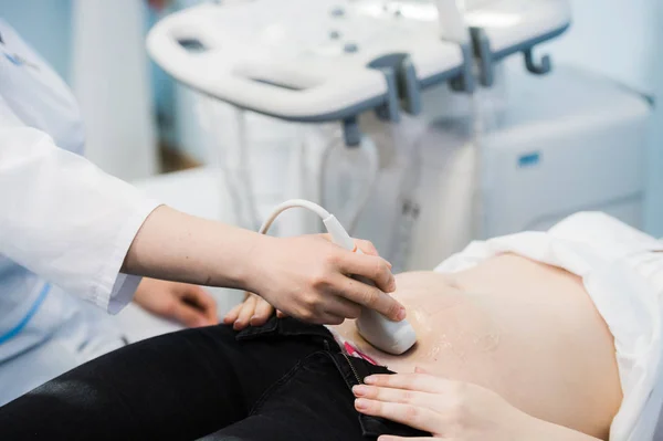 Nahaufnahme des Inkognito-Arztes mit Ultraschallgeräten zur Früherkennung schwangerer Frauen und Drücken der Tasten eines speziellen Computers. Frau in Klinik diagnostiziert — Stockfoto