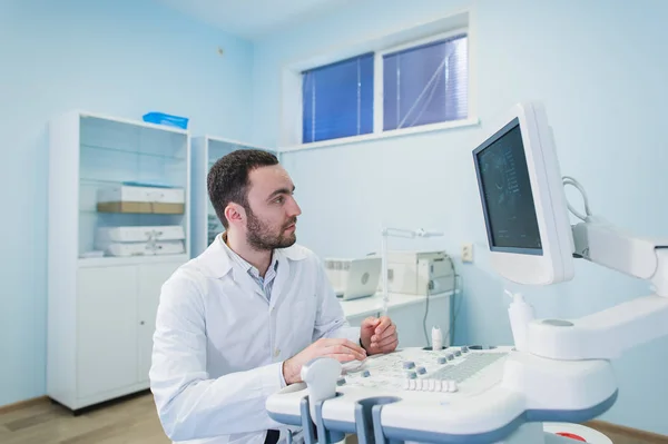 Porträtt av en tänkande läkare nära sceen medicinsk utrustning. — Stockfoto