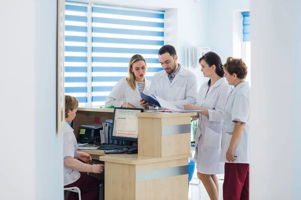 Médico y recepcionista en recepción en un hospital — Foto de Stock