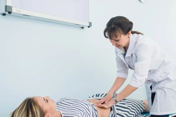 Médecins mains examinant l'abdomen féminin — Photo