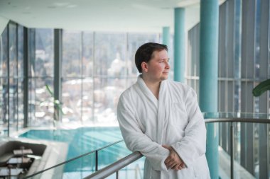 Adam bir elbise içinde bir havuz yanında duran ve rahatlatıcı