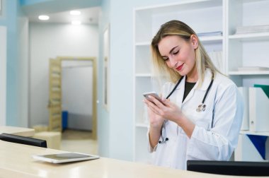kadın doktor kullanım cep telefonu, tıbbi işçisi kavramı gülümseyen