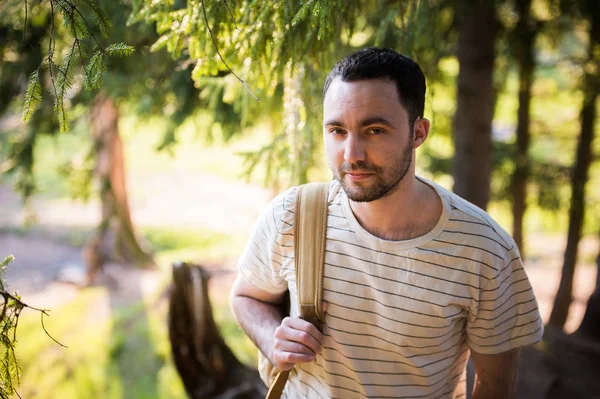 Sonriente hombre guapo feliz con barba en el bosque, montañas, parque. Hombre viajero relajándose. Viajes Estilo de vida senderismo concepto vacaciones de verano al aire libre. Hombre barbudo . — Foto de Stock