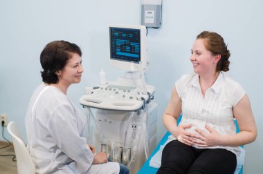 Doktor gösteren bebek ultrason görüntüsünün bilgisayara hamile kadına