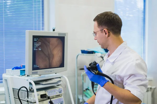 Proctólogo sosteniendo un anoscopio contra una silla proctológica. En el hospital. — Foto de Stock