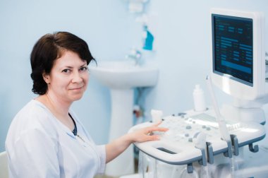 Ultrason tarayıcı kullanarak mutlu olgun kadın doktor. Echography makine