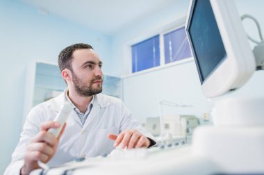 Tıbbi ekipman sceen yakınındaki bir düşünme doktor portresi.