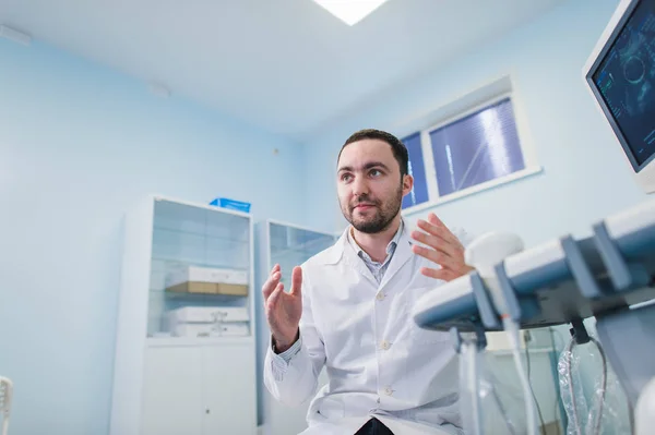 Jonge mannelijke arts uitleggen echografie zwangere vrouw in het ziekenhuis — Stockfoto