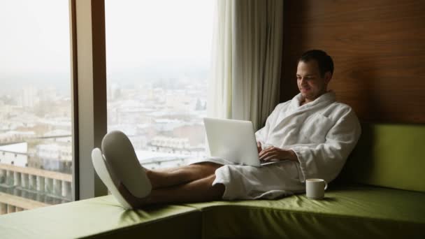 Joven freelancer trabajando desde casa en un portátil — Vídeos de Stock