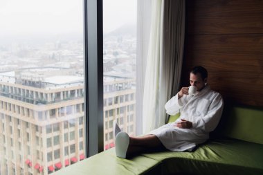 Onun sabah kahve onun otel odasında kendi bilgisayarında zevk çekici bir adam