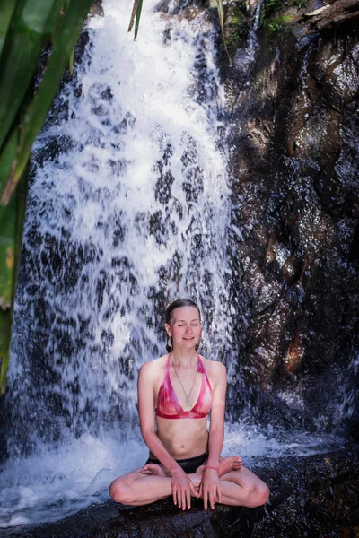 Young woman Practising Yoga meditating under Waterfall — Stock Photo, Image