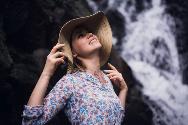 Ładna kobieta w kapeluszu, stwarzające przez wodospady lasu — Zdjęcie stockowe