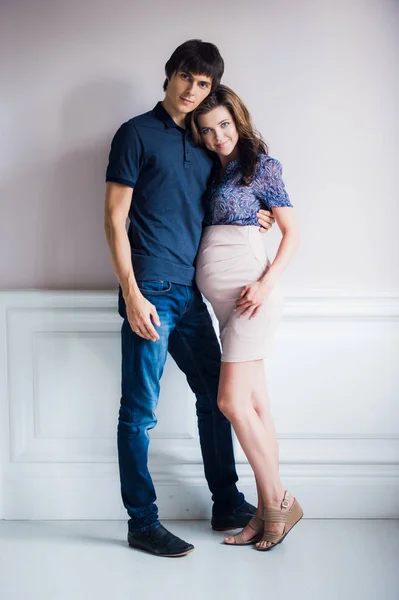 Foto di moda di bella coppia in abiti eleganti. bello giovane uomo in posa con splendida moglie incinta — Foto Stock