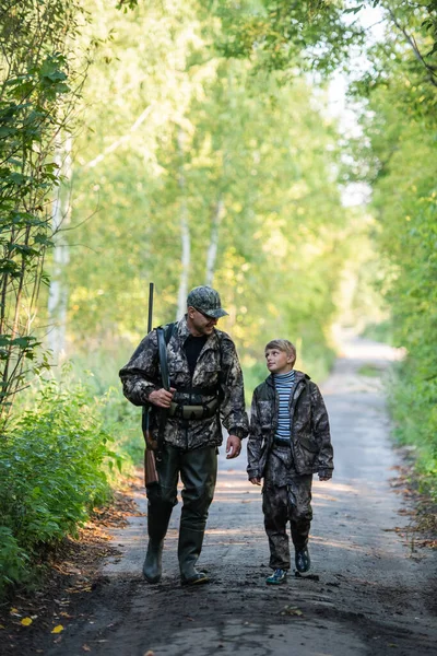 Baba, ilk geyik avında oğlunu işaret ediyor ve rehberlik ediyor.