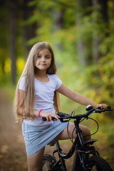 Schattig klein tiener meisje rijden fiets in een zonnig park — Stockfoto