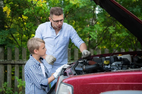 Padre e hijo están reparando el coche al aire libre. concepto de reparación de automóviles . — Foto de Stock