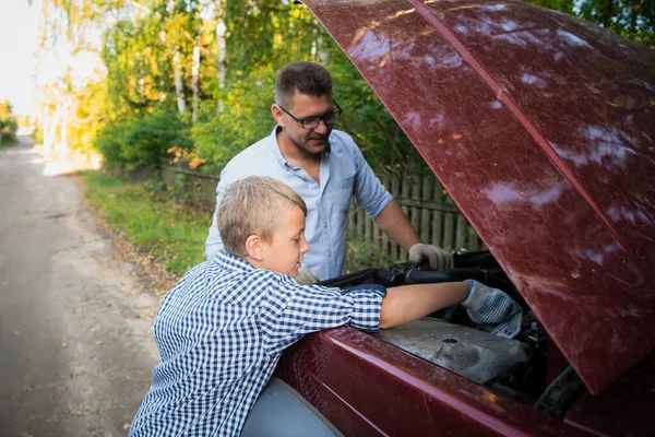 父は彼の息子は家族の車のオイルをチェックする方法を教える. — ストック写真