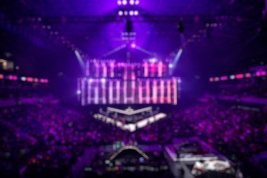 Esport etkinliğinin bulanık arkaplanı - ana sahne mekanı, büyük ekran ve turnuva başlamadan önce ışıklar.