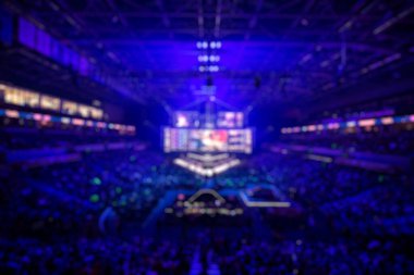 Esport etkinliğinin bulanık arkaplanı - ana sahne mekanı, büyük ekran ve turnuva başlamadan önce ışıklar.