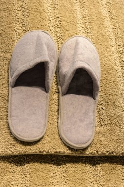 Sarı halıda bej ayakkabılar..