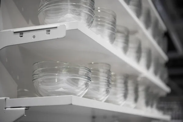 Fila de cuencos vacíos de vidrio blanco en un estante. Cuencos de vidrio en la tienda de utensilios de cocina . — Foto de Stock