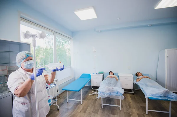 Enfermeira conectando um gotejamento intravenoso no quarto do hospital . — Fotografia de Stock