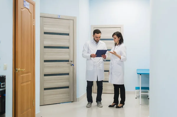 Médico maduro discutiendo con su colega sobre el diagnóstico en la oficina de hospitales . — Foto de Stock