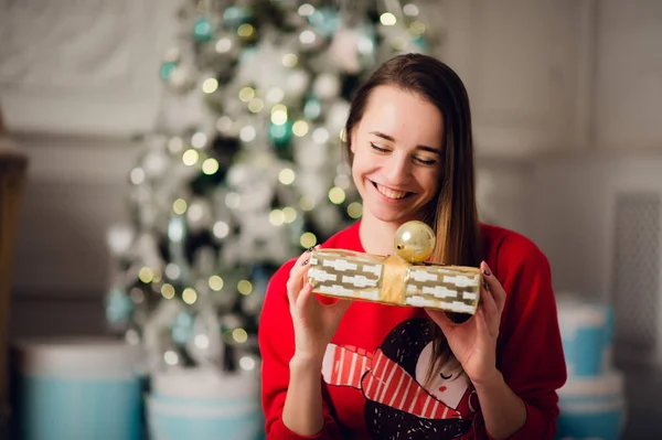 美しいです幸せな若い女性嘘床の上に保持クリスマスプレゼント — ストック写真
