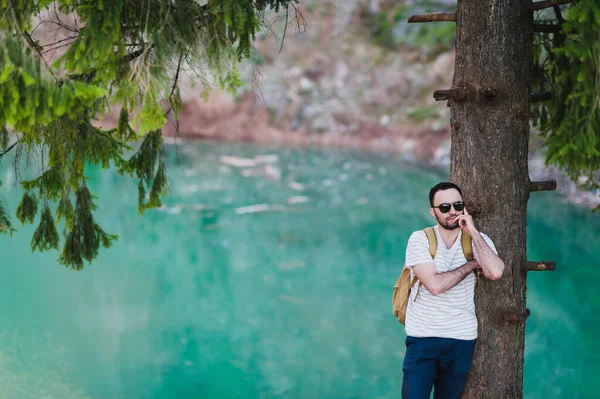 Γενειοφόρος άνδρας μοντέλο θέτει μαζί με ένα πράσινο του νερού στη λίμνη. — Φωτογραφία Αρχείου