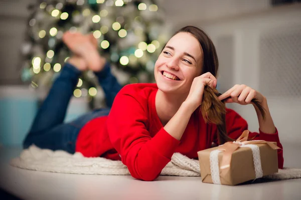 Foto von charmanten netten schönen attraktiven Mädchen mit einem Geschenk trägt Jeans und roten Pullover — Stockfoto