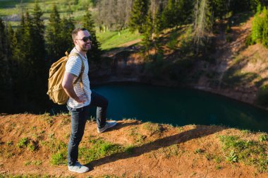 Adam içinde yansıtan gökyüzü göl yukarıda Uçurumdaki ayakta