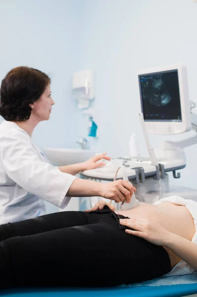 Läkare som utför en ultraljudsundersökning på gravid kvinna — Stockfoto