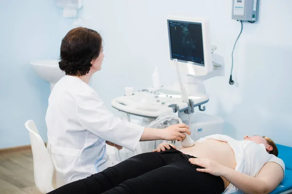 Šťastný zralý ženský doktor pomocí ultrazvukového skeneru. echografie stroj — Stock fotografie