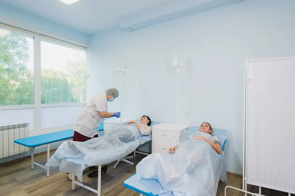 Медсестра подключает внутривенную капельницу в больничной палате . — стоковое фото