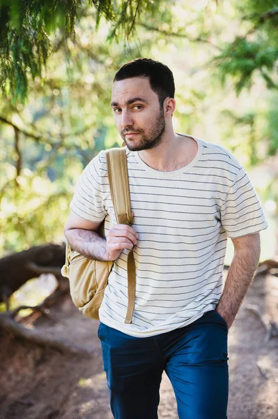 Senderismo retrato de hombre con mochila caminando en la naturaleza. Hombre caucásico sonriendo feliz con el bosque en el fondo durante el viaje de verano — Foto de Stock