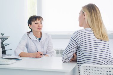 Kadın doktor ve hasta hastane ofisinde konuşmak. Sağlık ve tıp istemci hizmeti