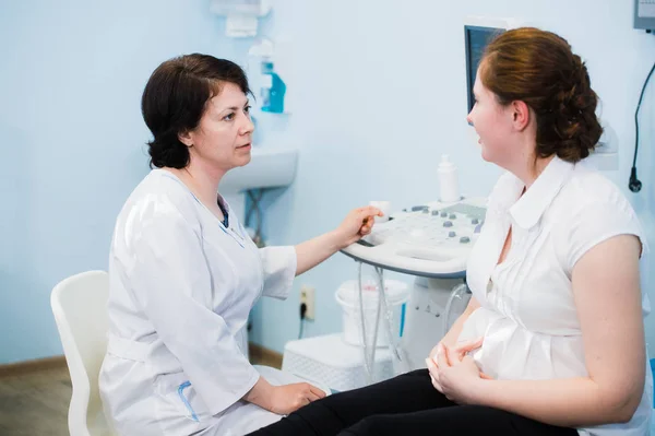 Gynecologist showing ultrasound photo to pregnant woman — Stock Photo, Image